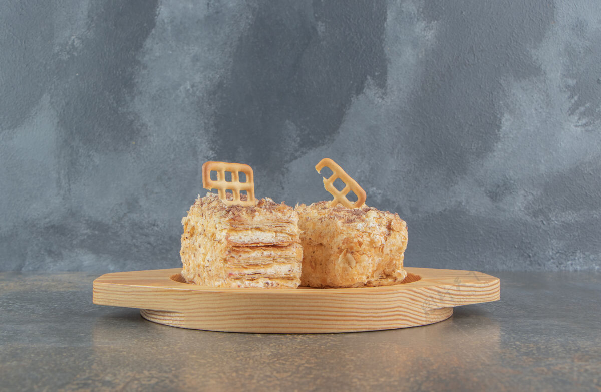 糕点把饼干放在木盘上的蛋糕片上蛋糕切片顶部