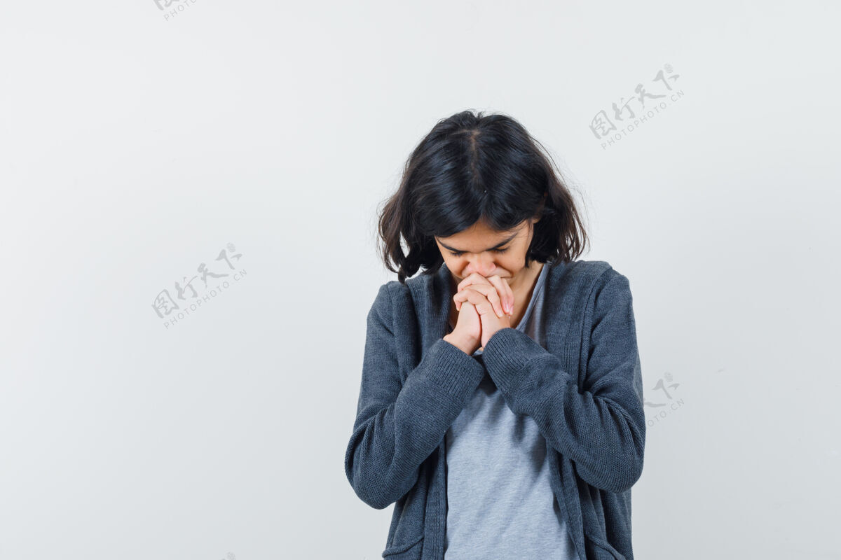 人小女孩抱着祈祷的手势在t恤衫 夹克衫和期待的手 正面视图休闲希望扣