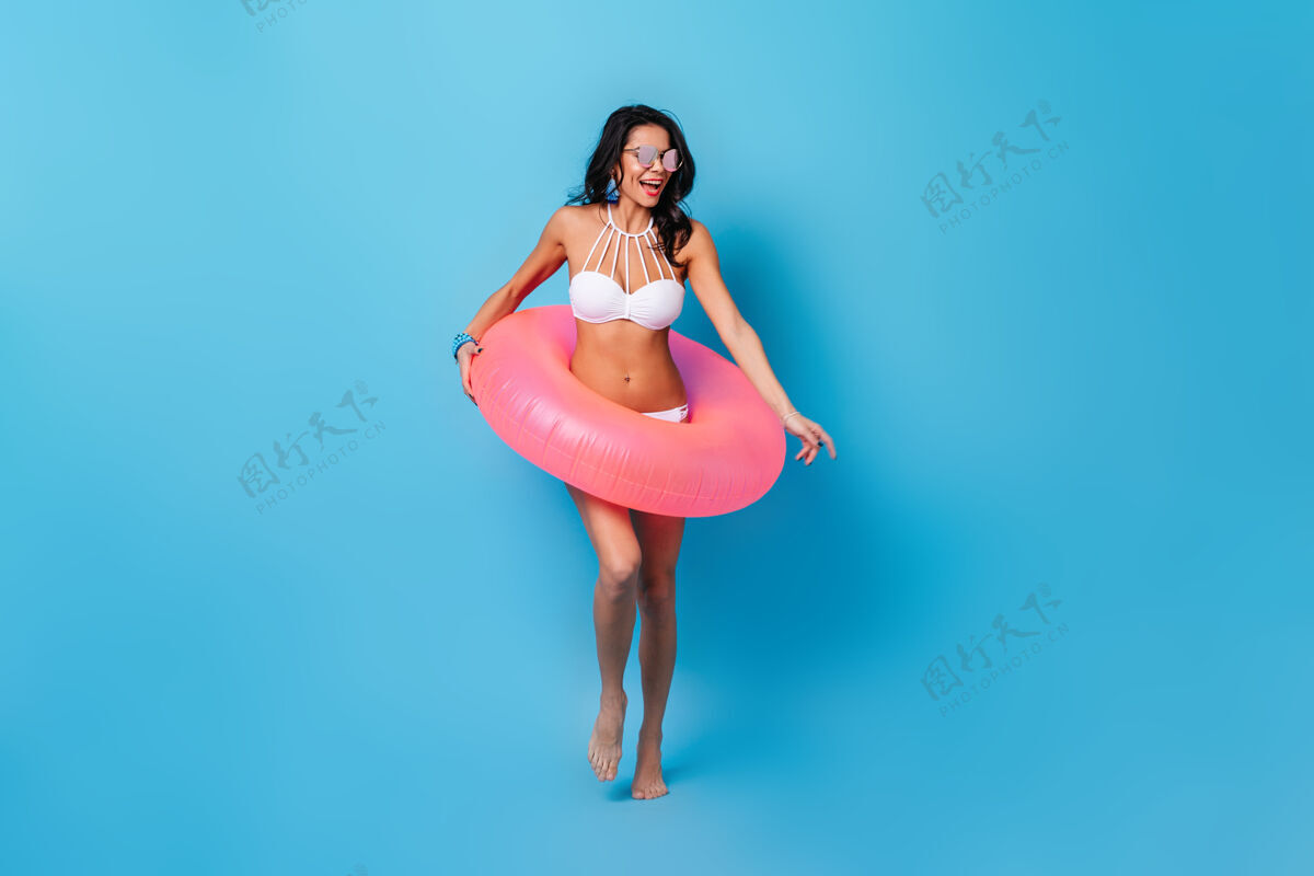 晒黑粉色游泳圈的迷人女人享受夏日时光欢呼活跃圈