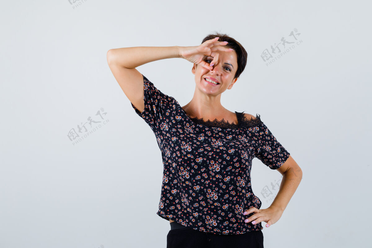 肖像成熟的女人在眼睛上展示ok的姿势 手放在衬衫的腰部 看起来很可爱前视图前面腰老年人