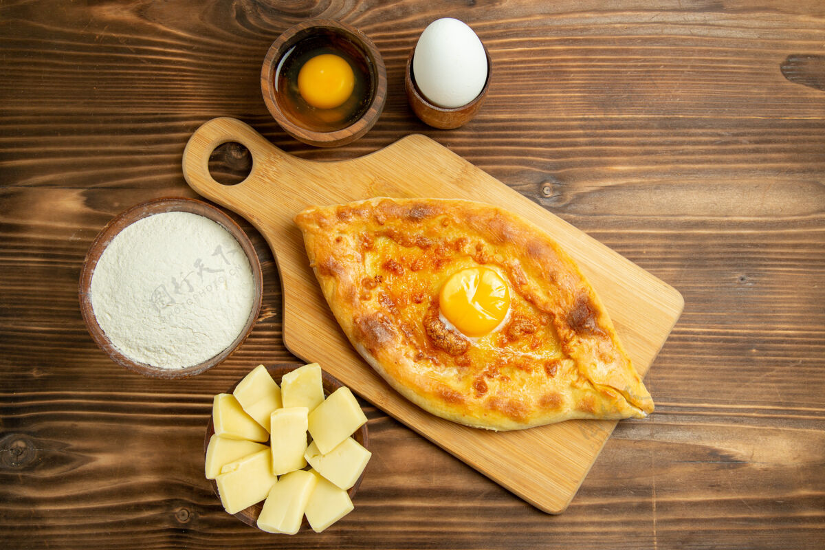 面团俯瞰美味的鸡蛋面包烤在棕色的木制桌子上面包面包包烤早餐鸡蛋面团顶部烘焙木头