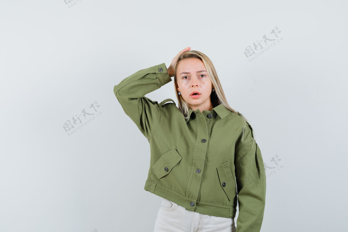 健康年轻女子手拉着手 头上穿着绿色夹克 牛仔裤 神情忐忑不安 俯瞰前方皮肤麻烦自然