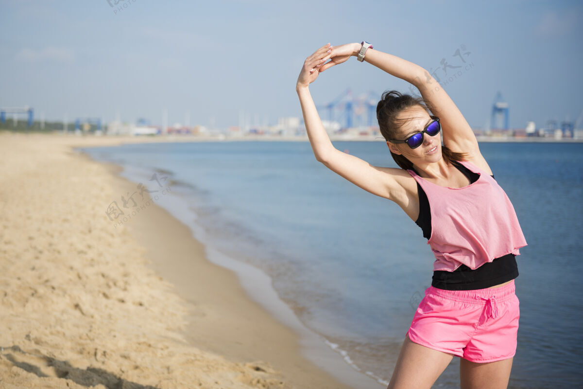 运动训练特写在海边慢跑的健康年轻人热身人手沙滩