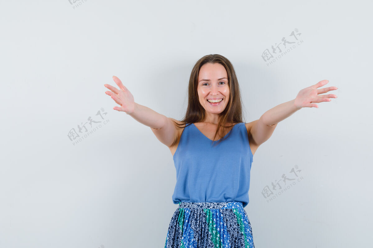 自然年轻的女士张开双臂拥抱在单身 裙子 看起来很快乐前视图单身年轻人