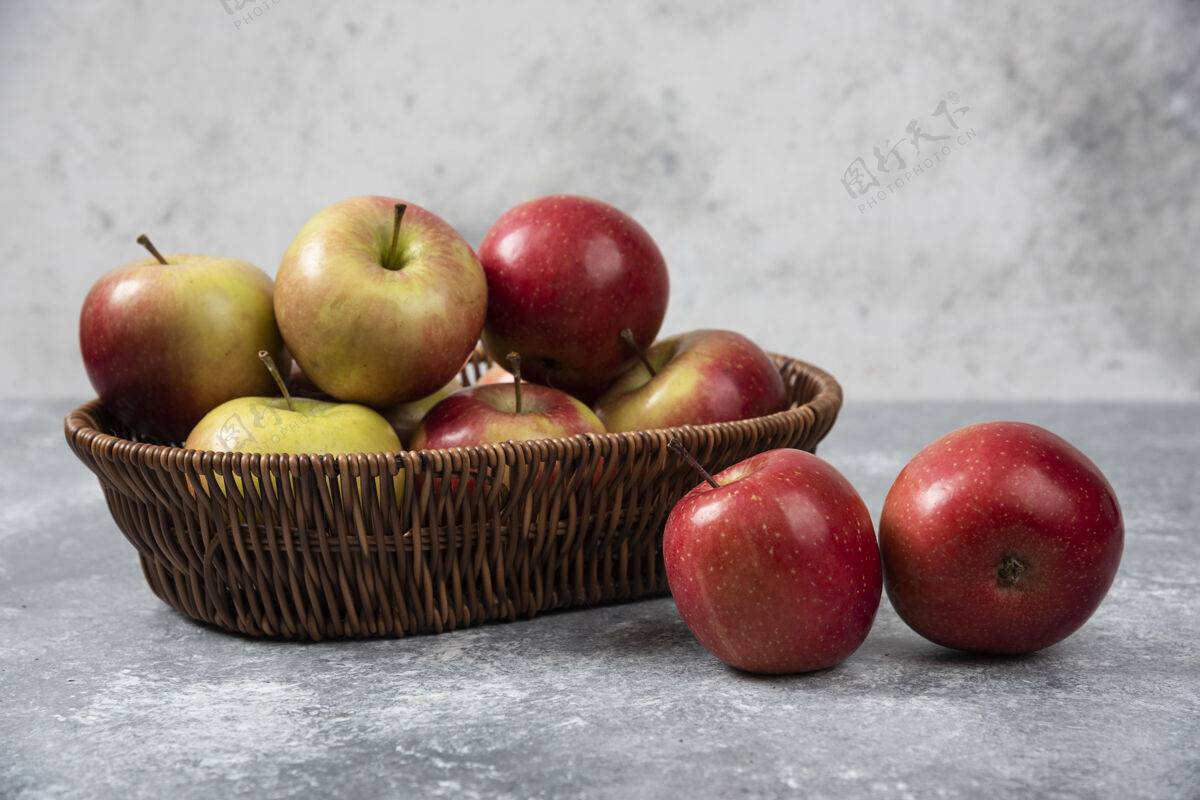 生的柳条篮红色多汁苹果大理石表面有机苹果水果