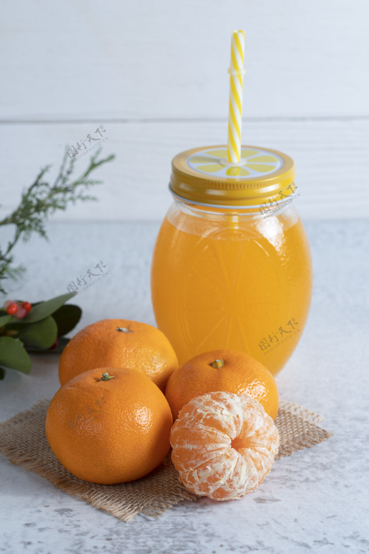 果汁石桌上有多汁的橘子和一罐橙汁成熟切稻草