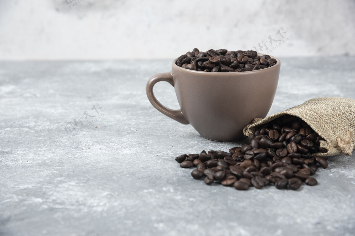 食物把咖啡豆从粗麻袋中取出 放在大理石上的杯子里豆类陶瓷粗麻布