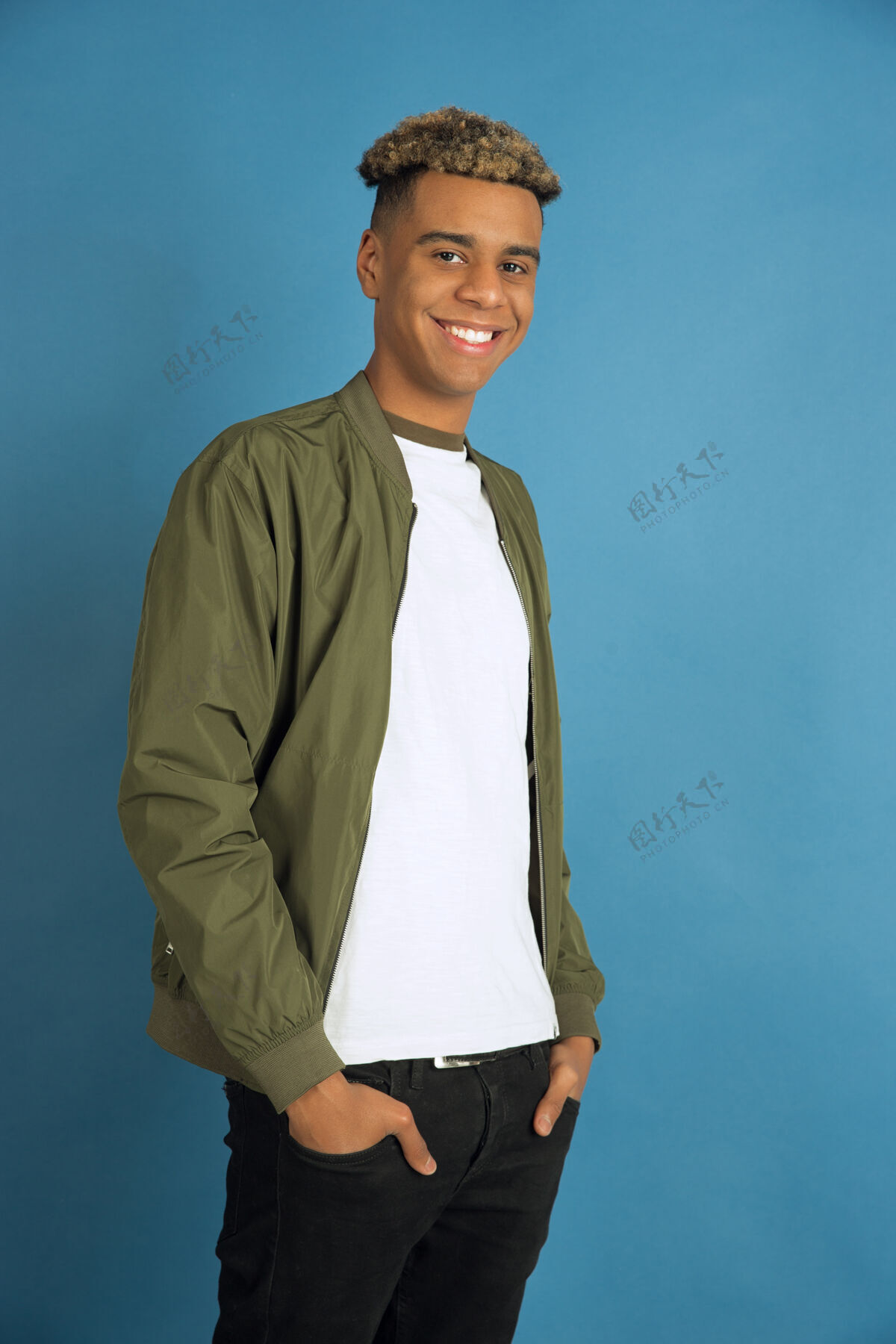 帅气自信和微笑非裔美国人的肖像隔离在蓝色的工作室背景上穿着休闲服的漂亮男模人类情感的概念 面部表情 销售 广告空间面部长度颜色