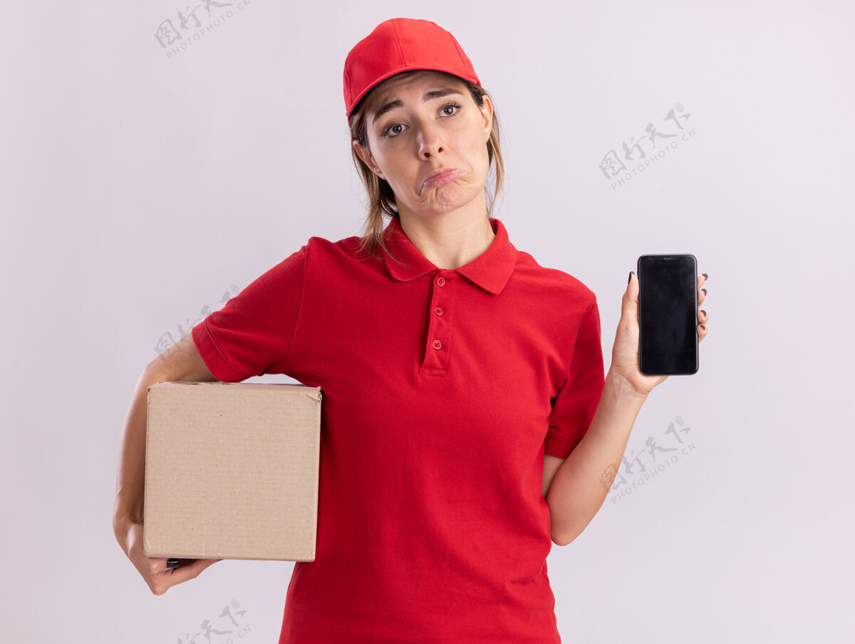 感觉悲伤的年轻漂亮的女送货员穿着制服 把名片盒和电话隔在白墙上电话人年轻