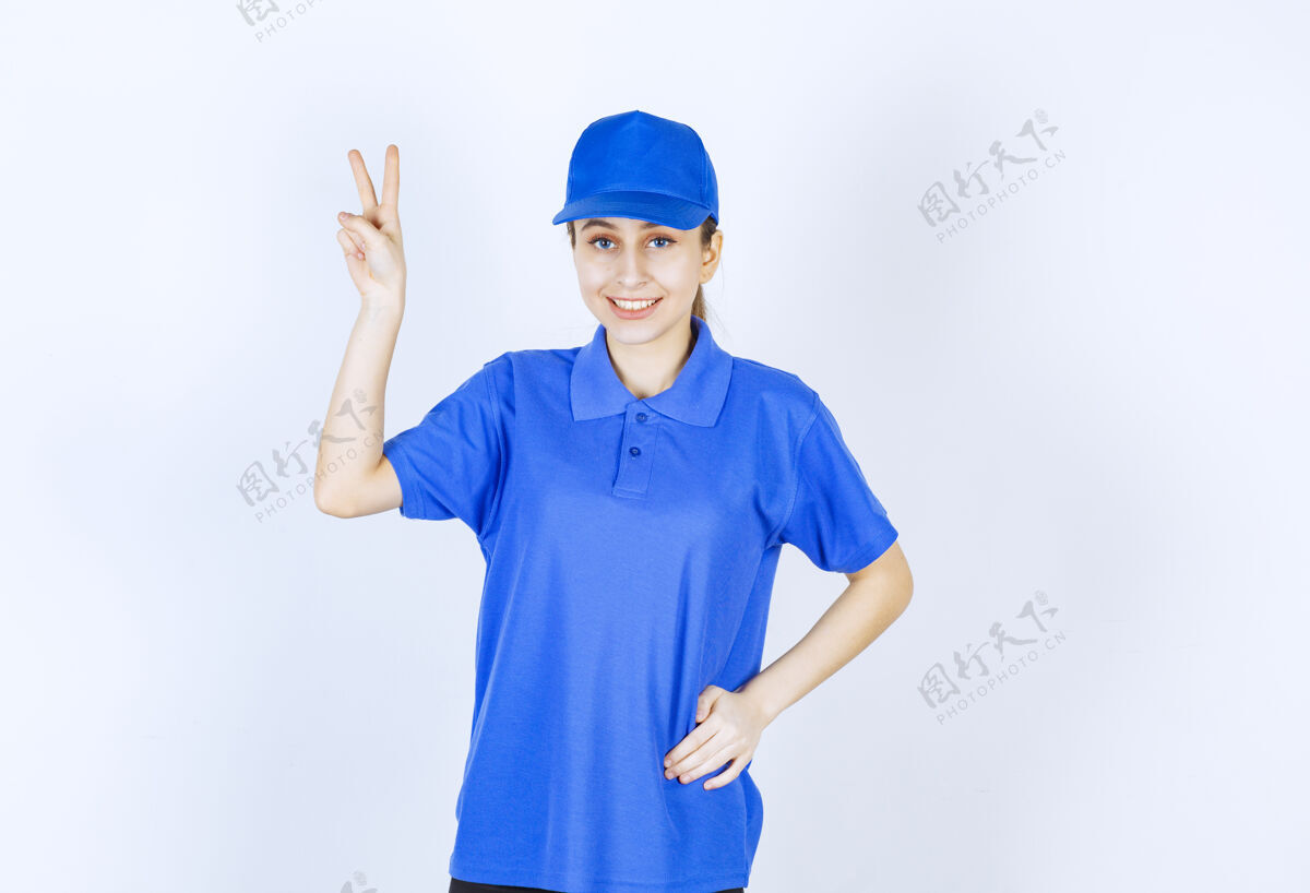 工人穿蓝色制服的女孩展示着享受的标志员工好年轻人