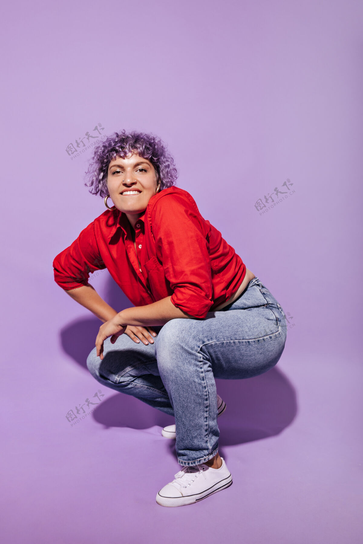 年轻现代女性 紫色卷曲短发 穿着亮色衬衫 白色运动鞋和裤子 咬着嘴唇 蹲在丁香上红衬衫肖像短发