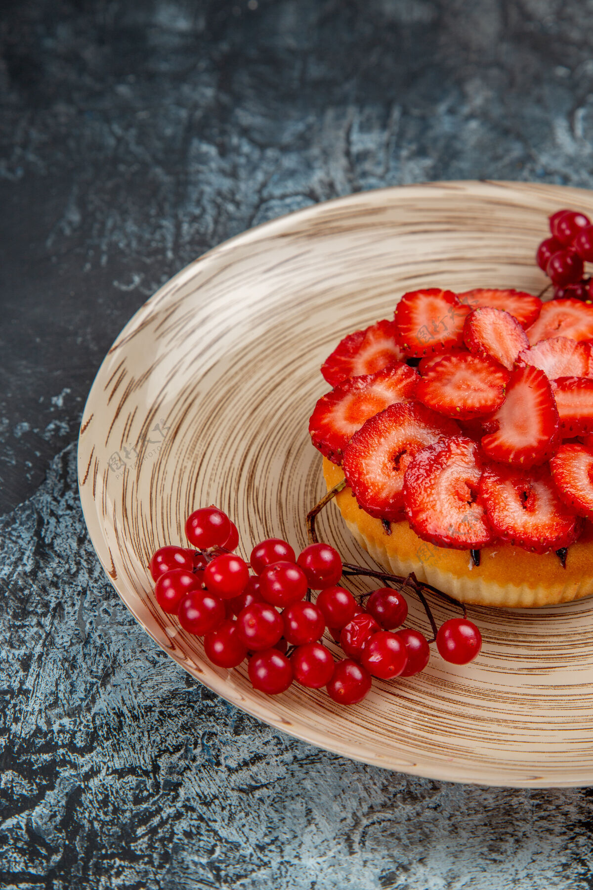 成熟正面是美味的草莓蛋糕和红色浆果在黑暗的表面甜点正面水果