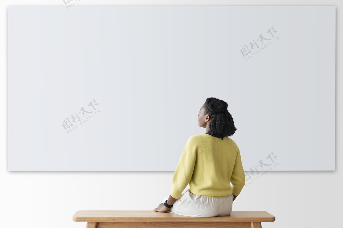 人女人在看空白墙的后视图屏幕背部视觉