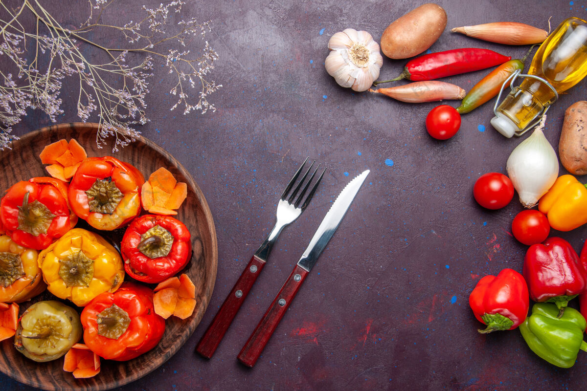 烹饪顶视图煮熟的甜椒配上新鲜的蔬菜 在深灰色的表面上吃蔬菜肉多尔玛食物午餐洋葱生的