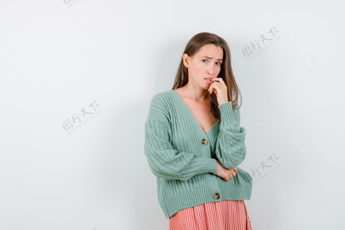 模特年轻女孩咬着手指 手挽着手肘下的针织衫 焦急地看着裙子 眼前一亮销售针织品卷发