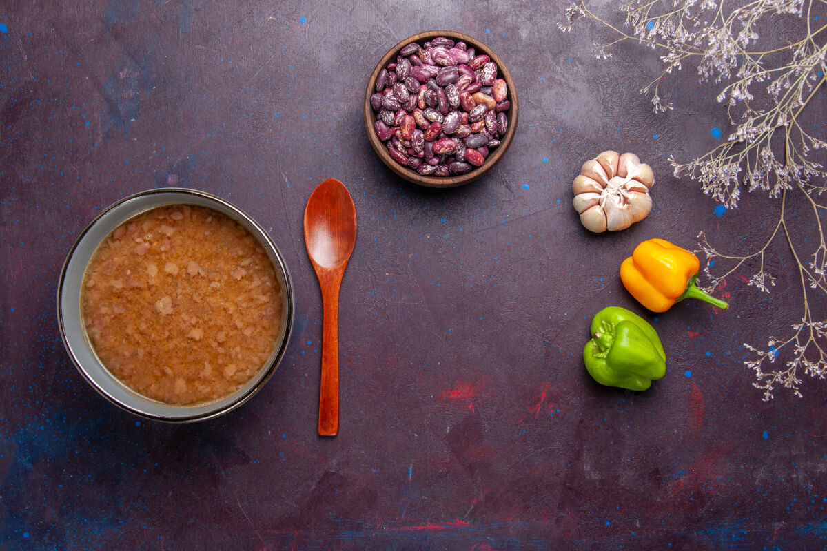 晚餐顶视图褐色的汤在盘子里用豆子放在深色的表面上汤蔬菜餐食物菜油香料膳食顶部