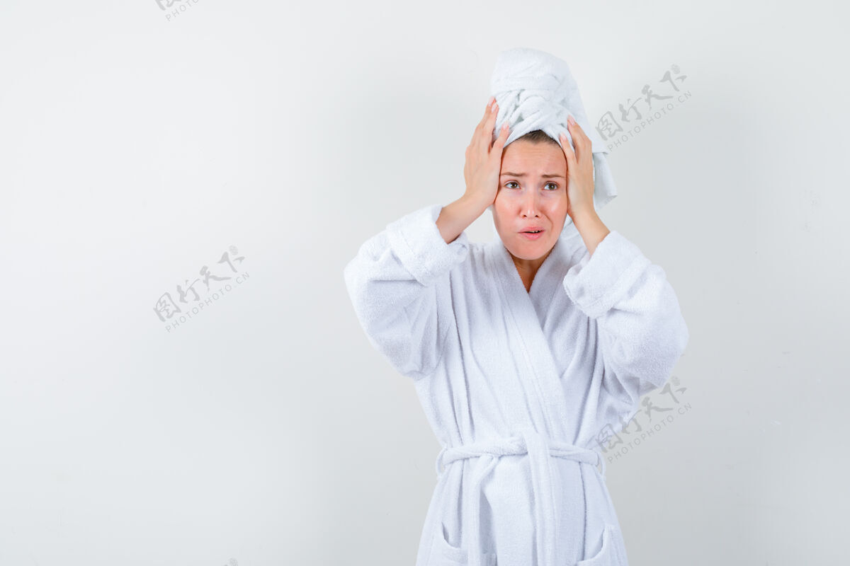 室内年轻的女人手放在头上 穿着白色浴衣 毛巾 神情渴望正视图毛巾漂亮友谊