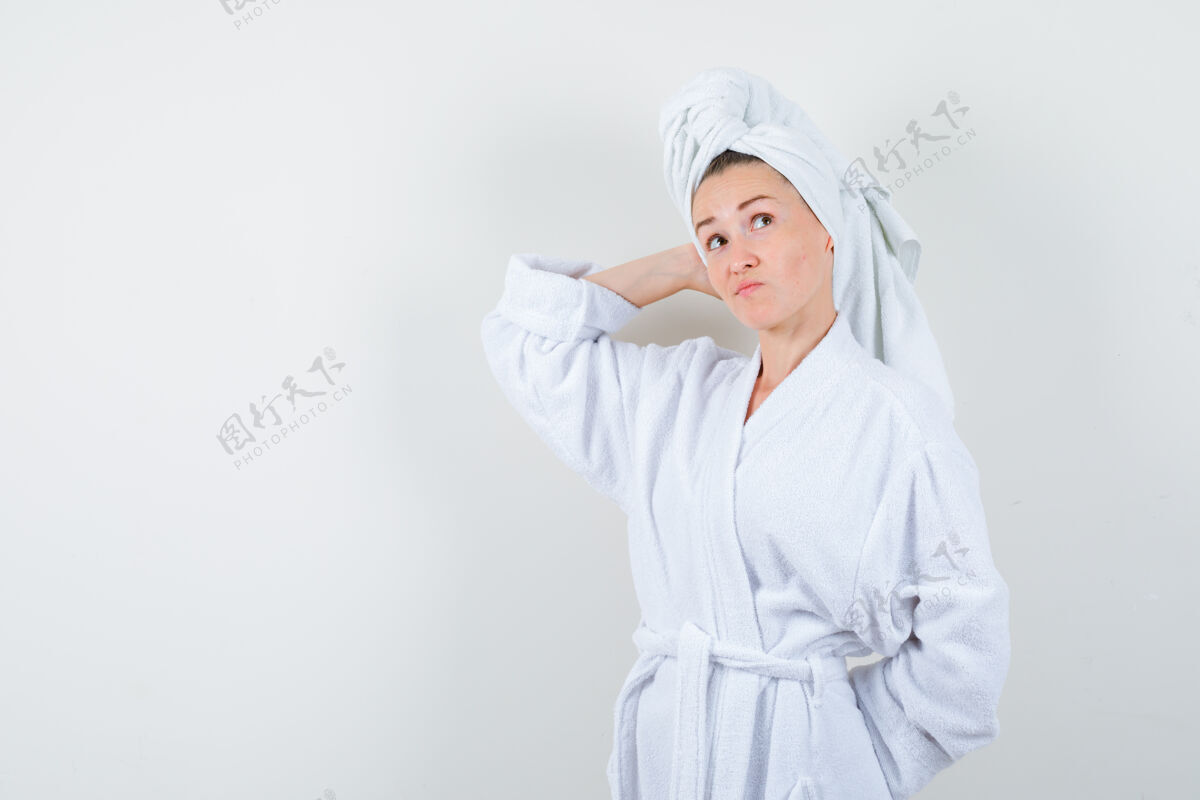 保持年轻女子手放在头上 穿着白色浴衣 拿着毛巾 神情优柔寡断 前视成人时尚黑发