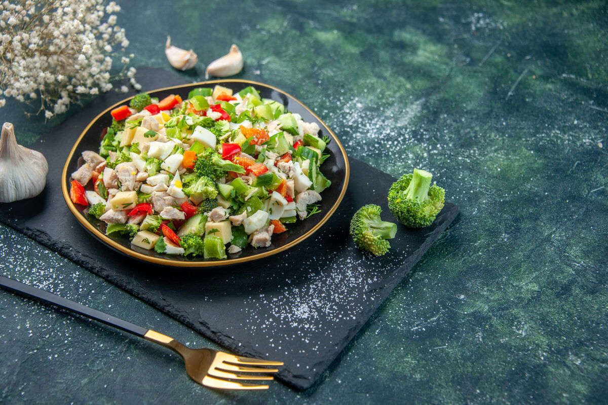 晚餐前视图美味蔬菜沙拉在深蓝色背景板内新鲜沙拉美食
