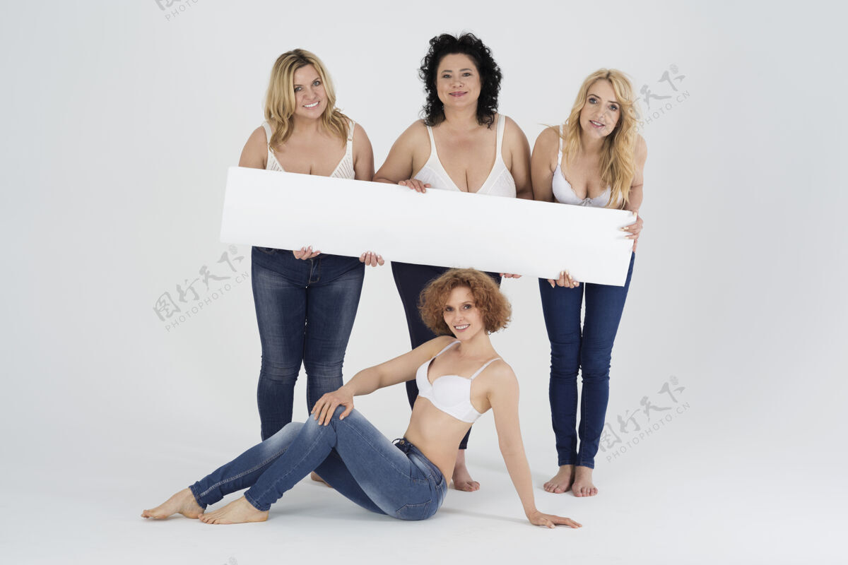 坐着特写成年妇女穿着牛仔裤 手持白色广告牌自信白板女人