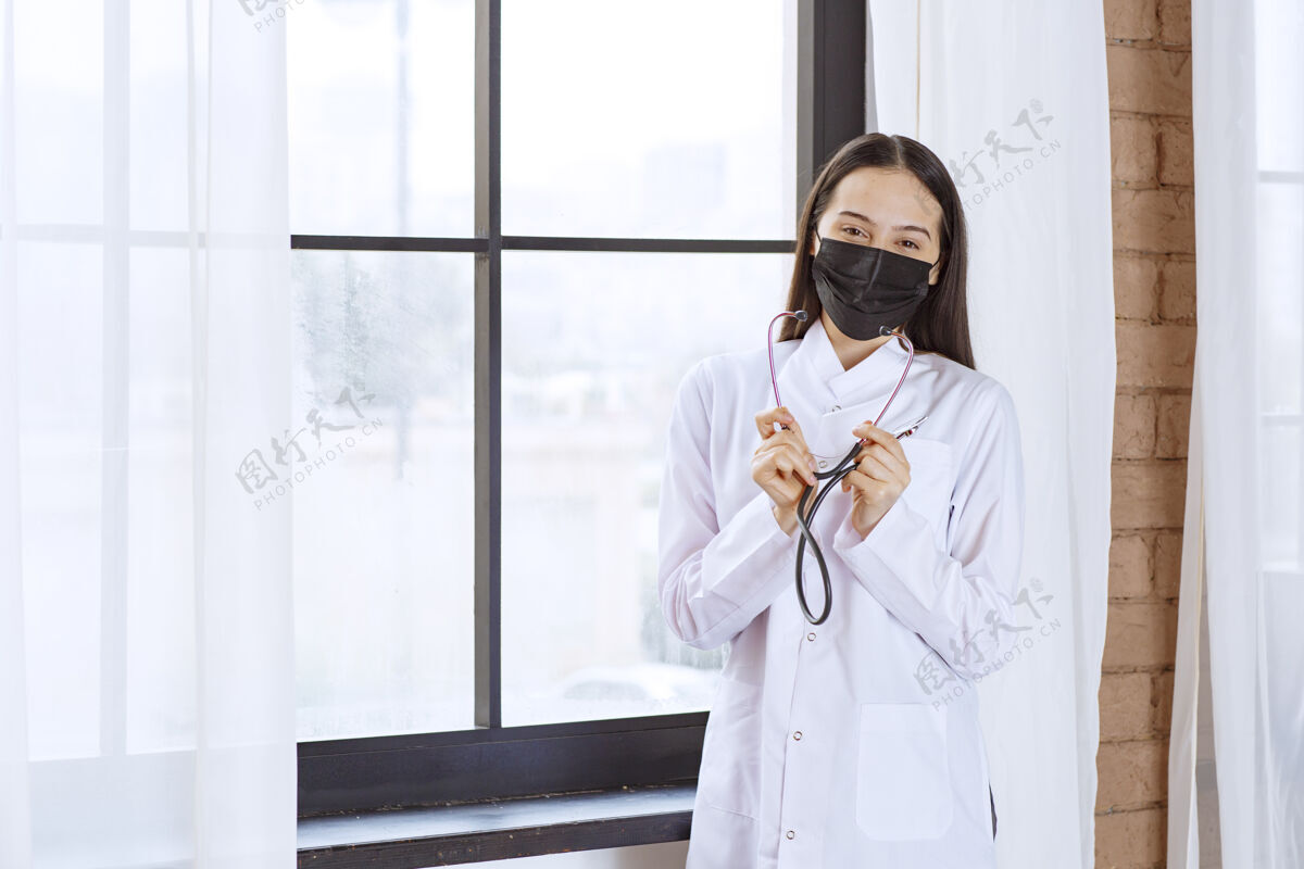 仪器戴着黑色口罩的医生站在窗边 带着听诊器医院医疗设备