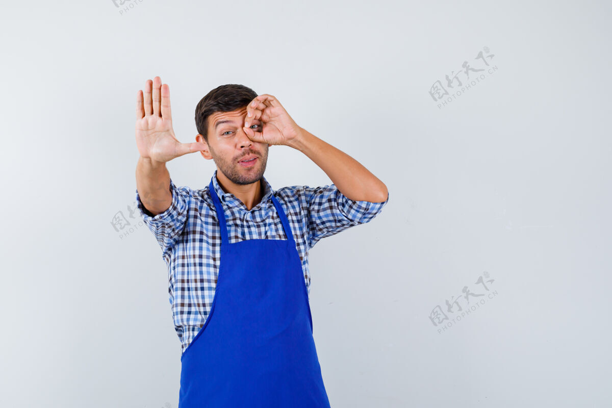 成人穿着蓝色围裙和衬衫的年轻男厨师男士帅哥男士
