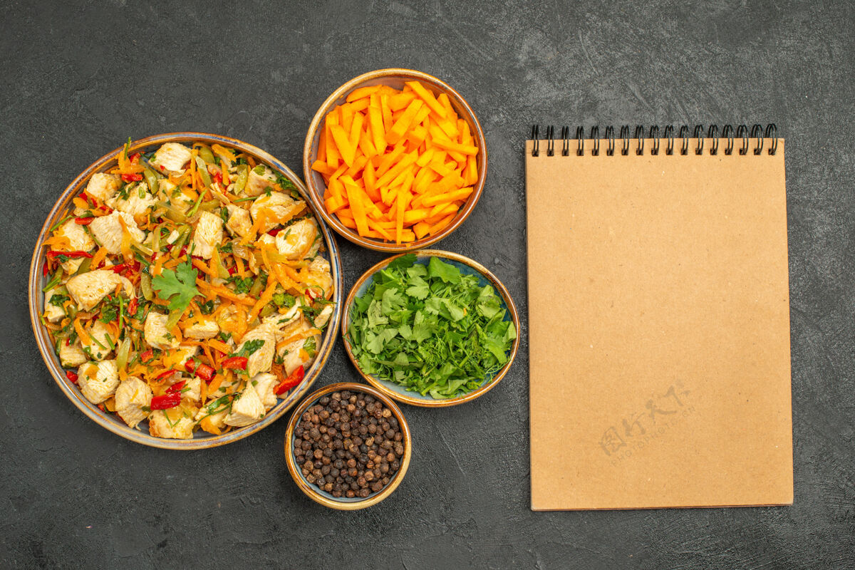 鸡肉沙拉俯视图鸡肉沙拉与蔬菜和蔬菜在黑暗的桌子饮食沙拉健康蘸酱盘子蔬菜