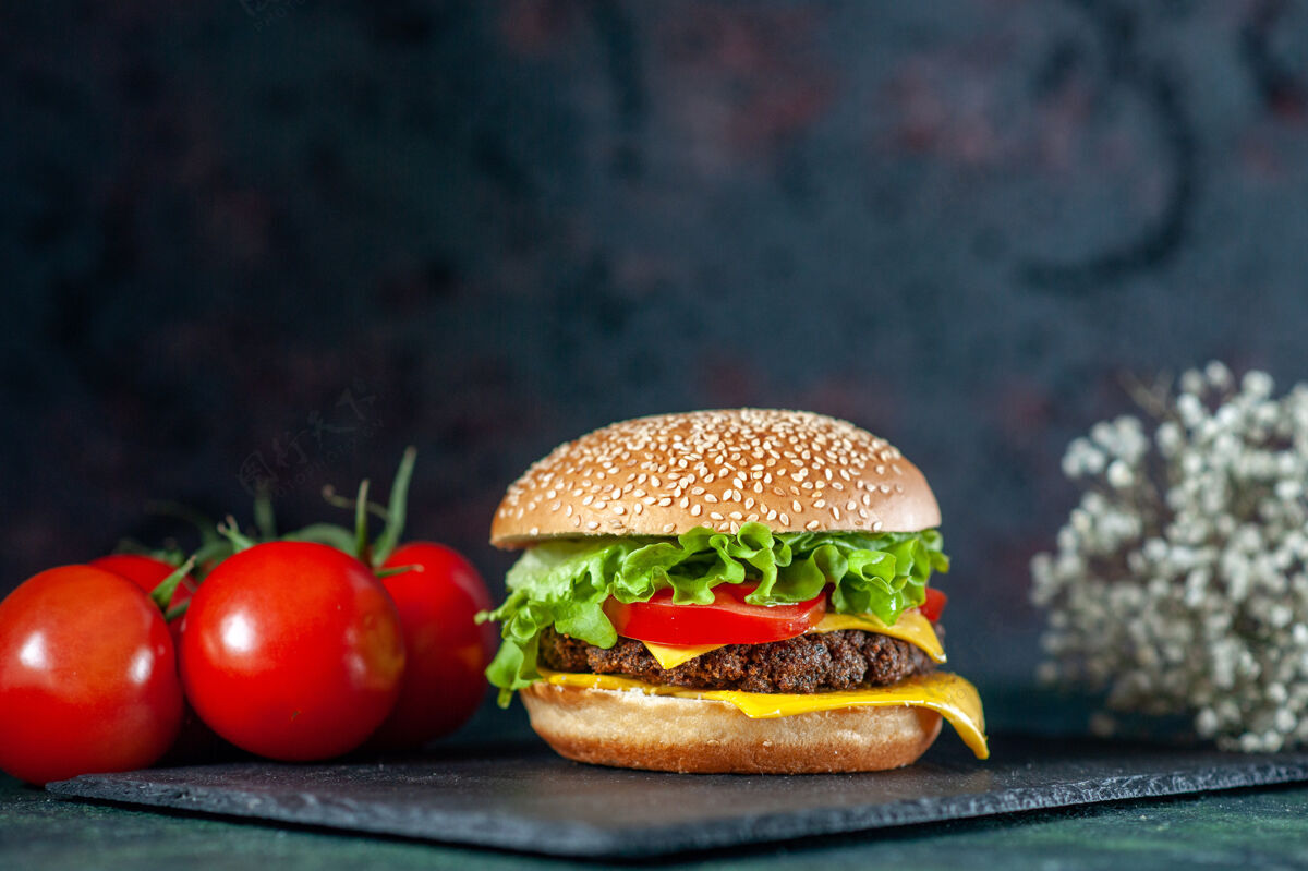 汉堡包前视图美味的肉汉堡包与红色西红柿在黑暗的背景正餐快餐番茄