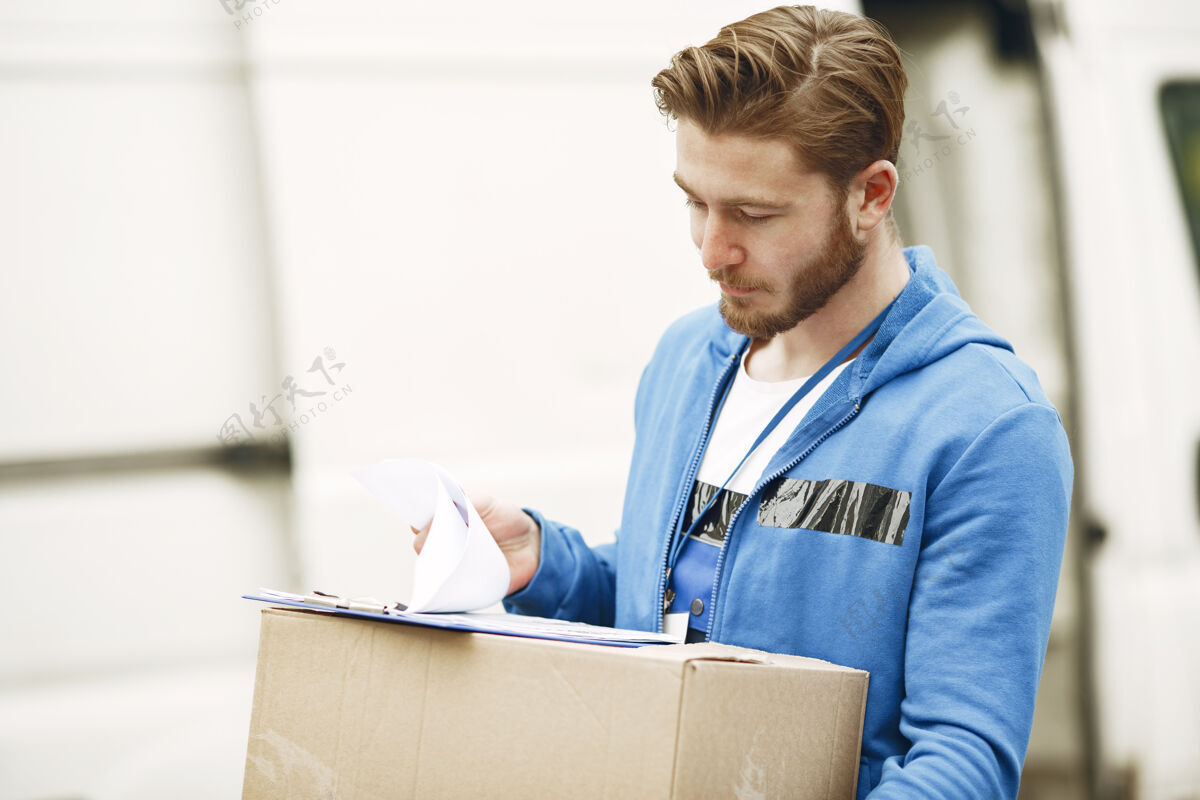 包装卡车旁的人穿着送货制服的人拿着剪贴板的人业务送货工作