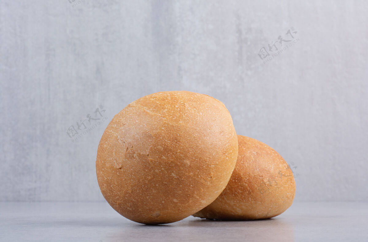 小吃圆圆的汉堡包放在石头表面香面包房饮食