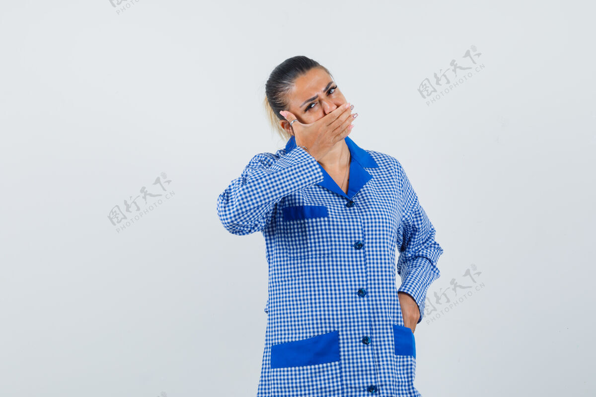 前面年轻女子用手捂住嘴 穿着蓝色方格布睡衣 看起来很漂亮正面图成人封面人