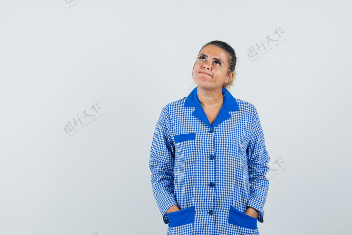 女性年轻女子把手放在口袋里 一边想着穿蓝色方格布睡衣的东西 一边沉思着 从正面看去新鲜干净沉思