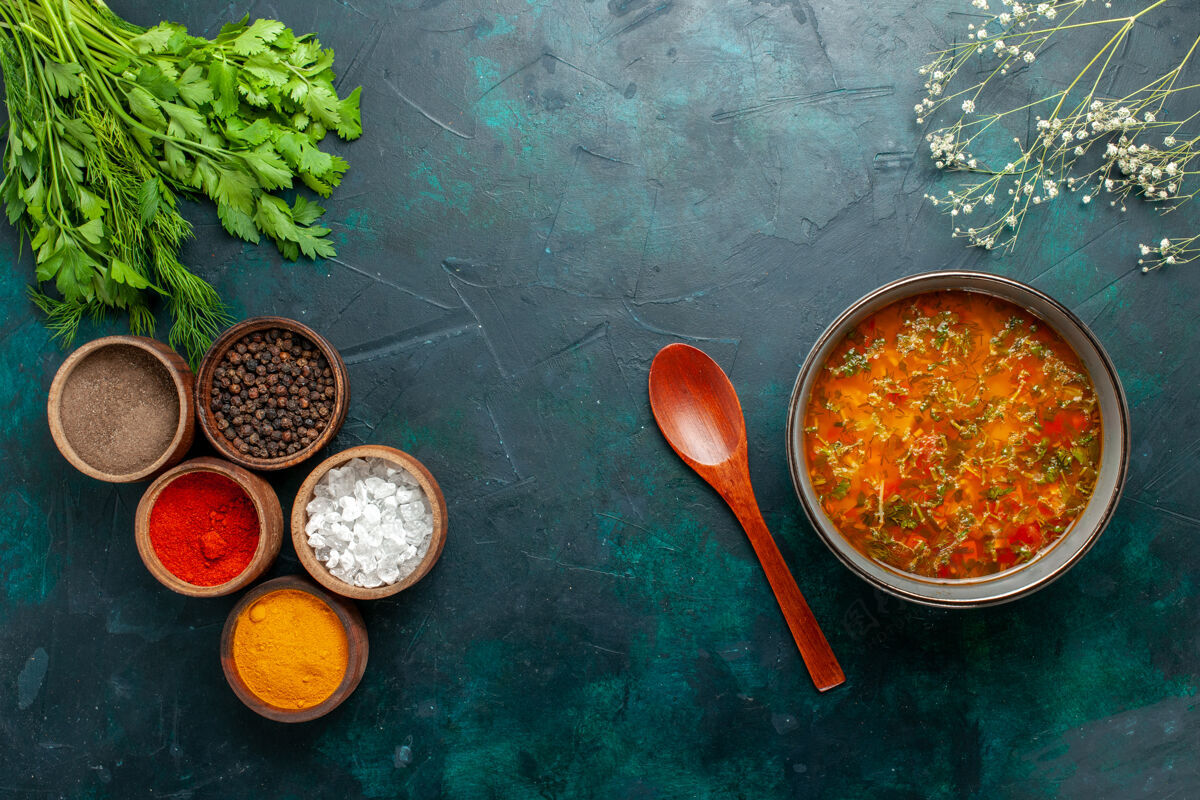 容器俯瞰美味的蔬菜汤与不同调味料的深绿色桌上食物餐蔬菜汤配料产品顶部桌子深绿色