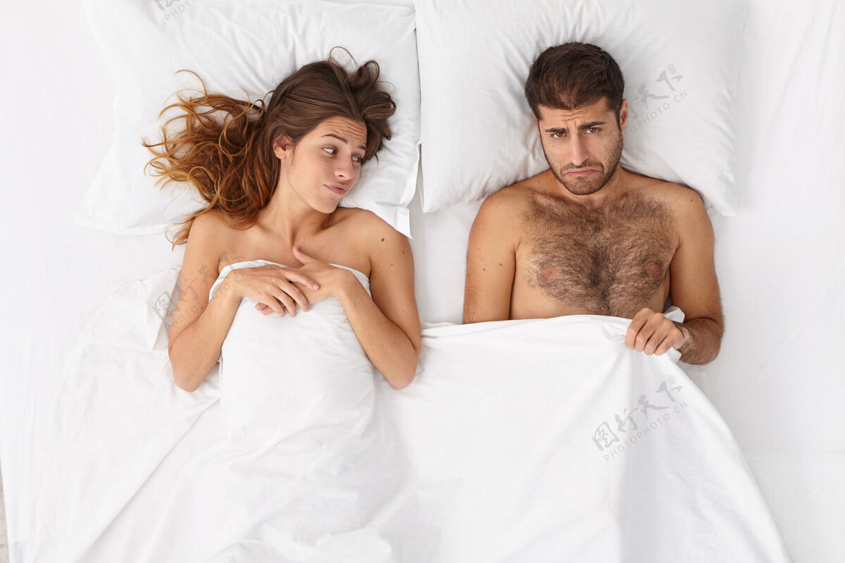 失望男性阳痿有勃起功能障碍 表情沮丧地躺在毯子下 不满意的女人躺在旁边 因为性失败有关系问题男性健康和阳痿观念卧室问题白种人