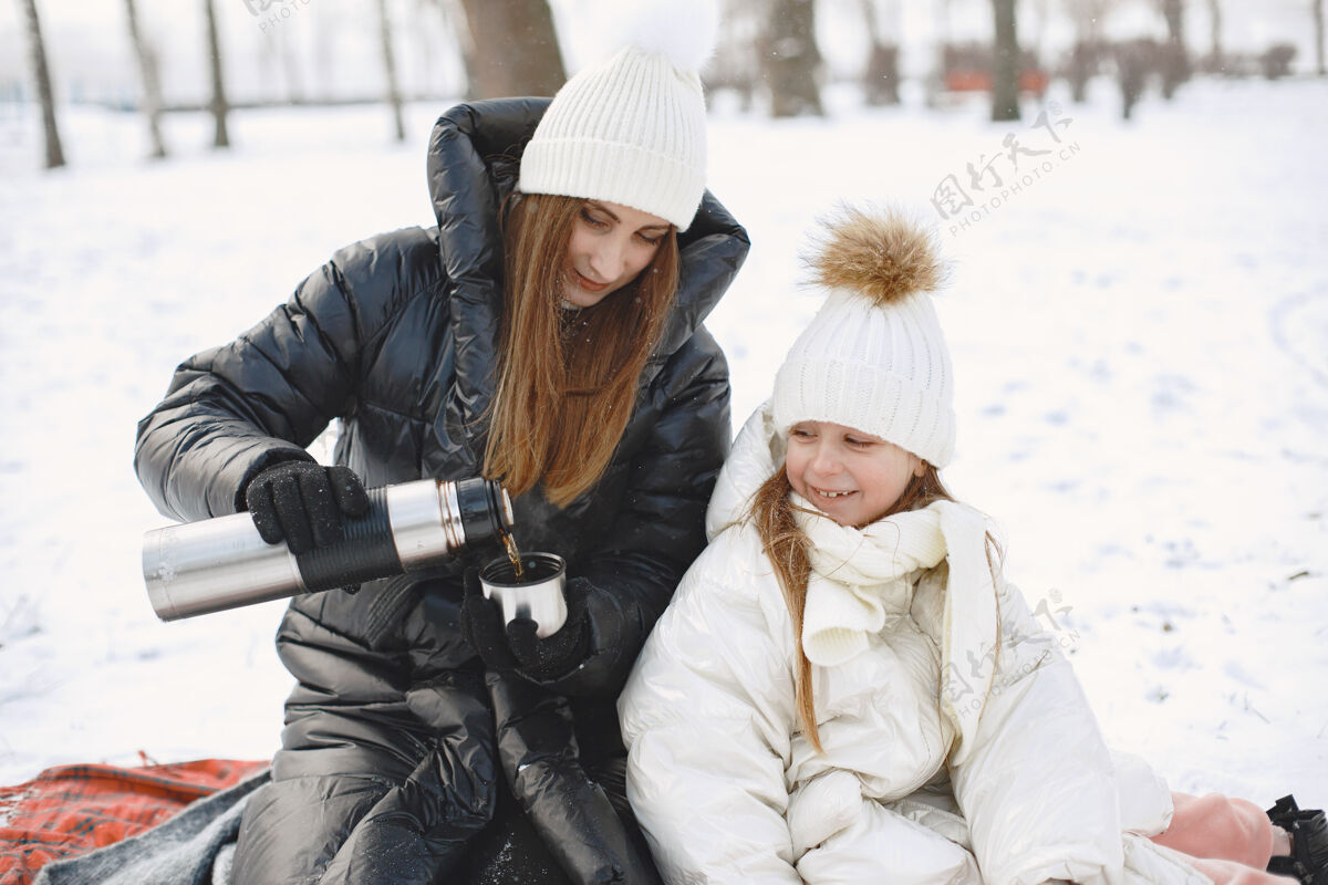 冬天一家人在度假时戴着编织的冬帽小季节夹克
