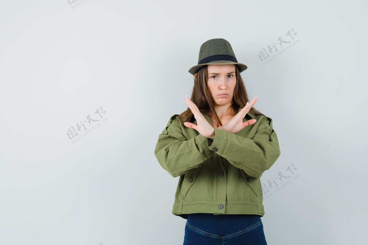 疲惫穿着夹克 裤子 帽子的年轻女士摆出停止的姿势 看起来很累夹克显示裤子