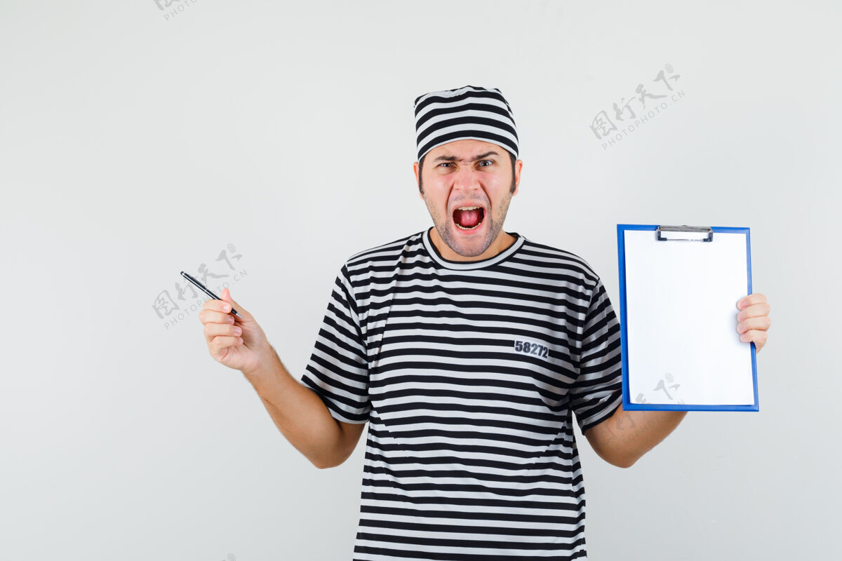前面年轻的男人拿着写字板和笔 穿着t恤 戴着帽子 看起来很生气思想模型男性