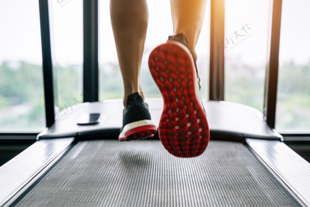 设备穿着运动鞋在健身房跑步机上跑步的男性脚运动概念向上鞋子机器