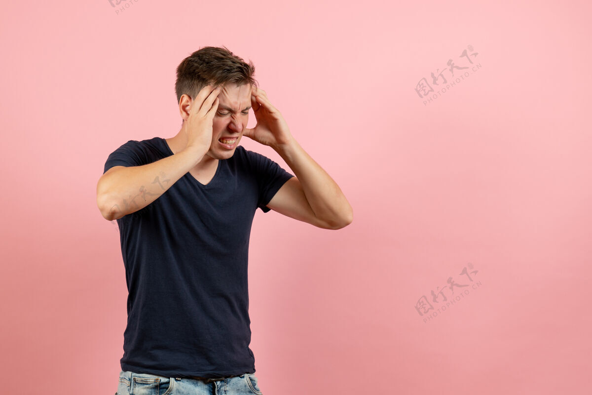 衬衫正面图粉色背景上穿着深蓝色衬衫头痛的年轻男性男性人类情感色彩男模情感正面头痛