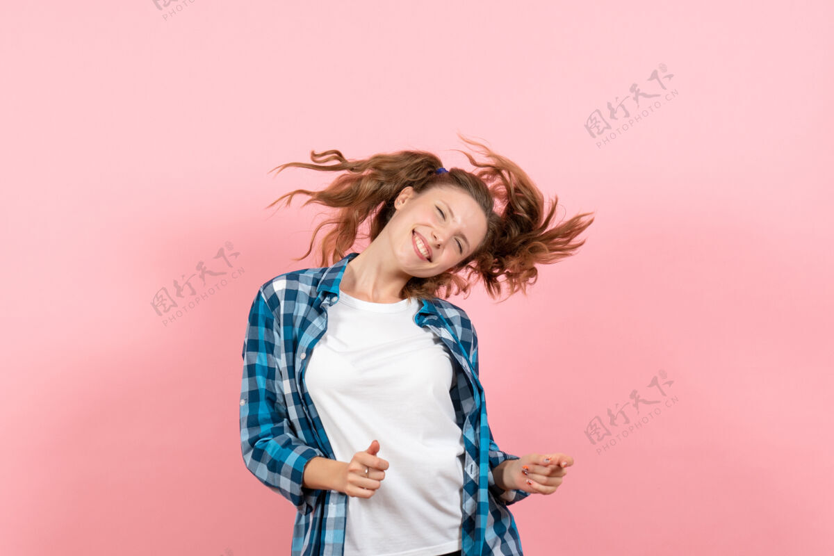 成人正面图：穿着格子衬衫的年轻女性在粉色背景上自由摆姿势 感受青春模特的情感 女人 小孩 女孩情感女孩姿势