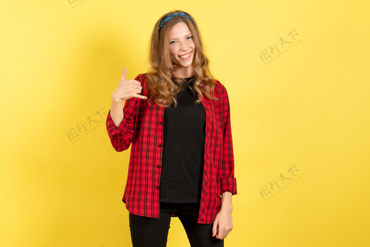 格子正面图身着红色格子衬衫的年轻女性在黄色背景上感受快乐人类女孩情感色彩模特女人人类感情漂亮