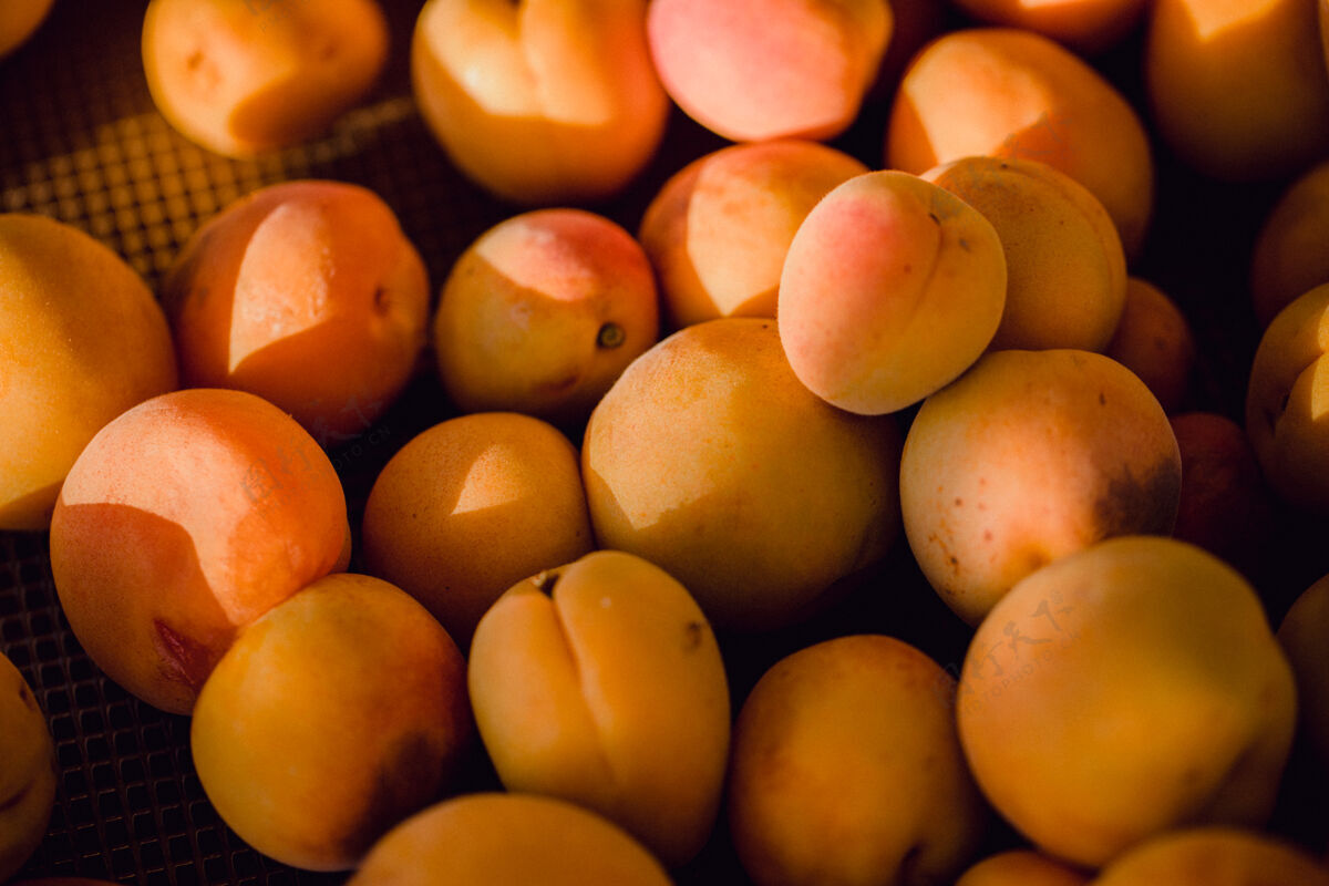 水果黄色的圆形水果放在棕色的木桌上农产品杏子食物