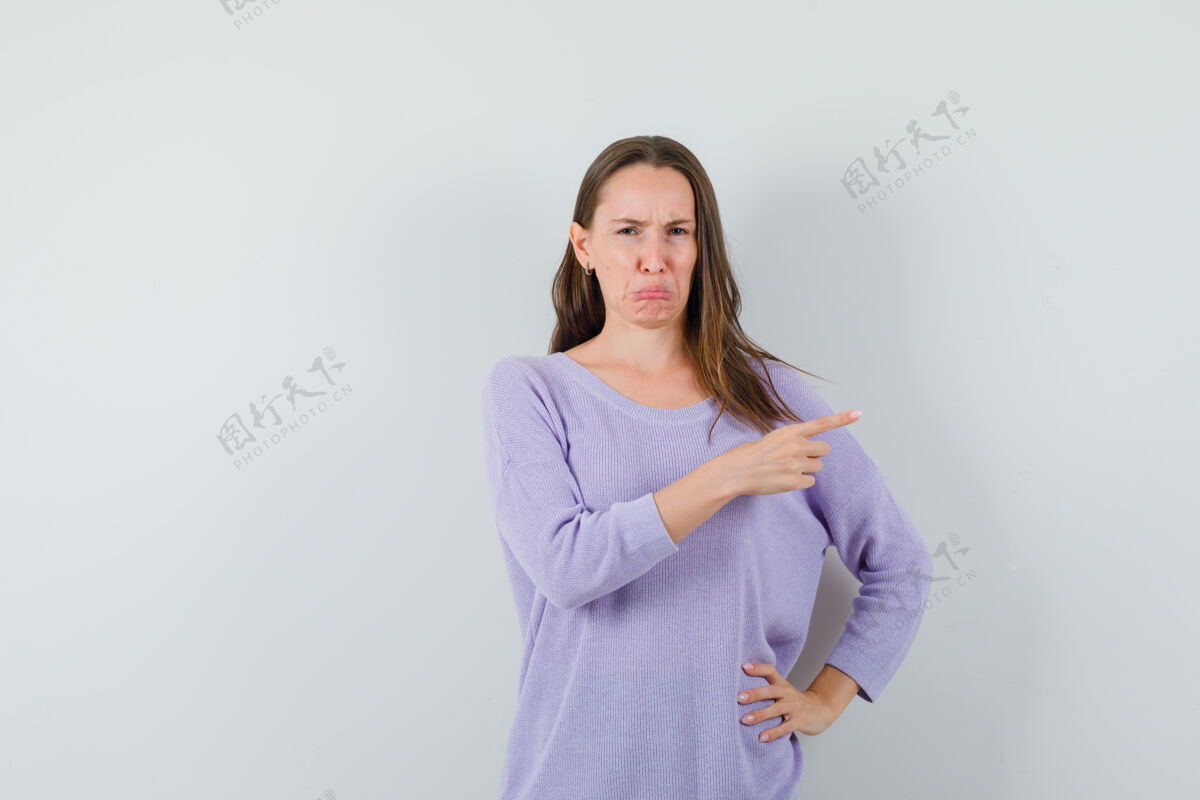 自信穿着淡紫色上衣的年轻女子指着一边 看上去很不高兴头发指向手