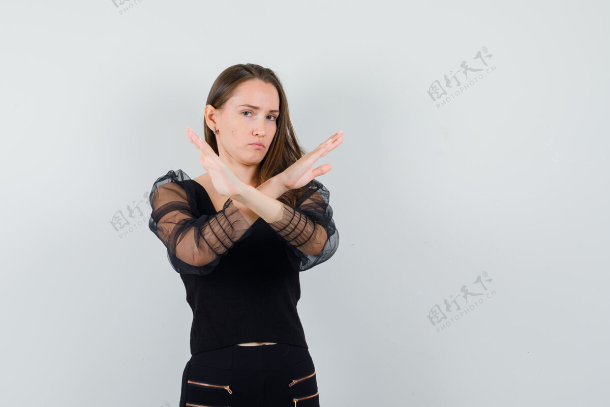 美女模特一个穿着黑色上衣 表情严肃的年轻女子 展示着封闭的姿态正面视图文本空间手势封闭头发