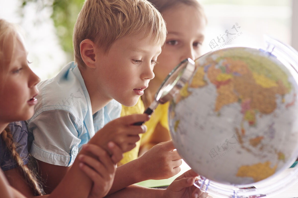 俯视孩子们在地理课上用放大镜地球知识瘦
