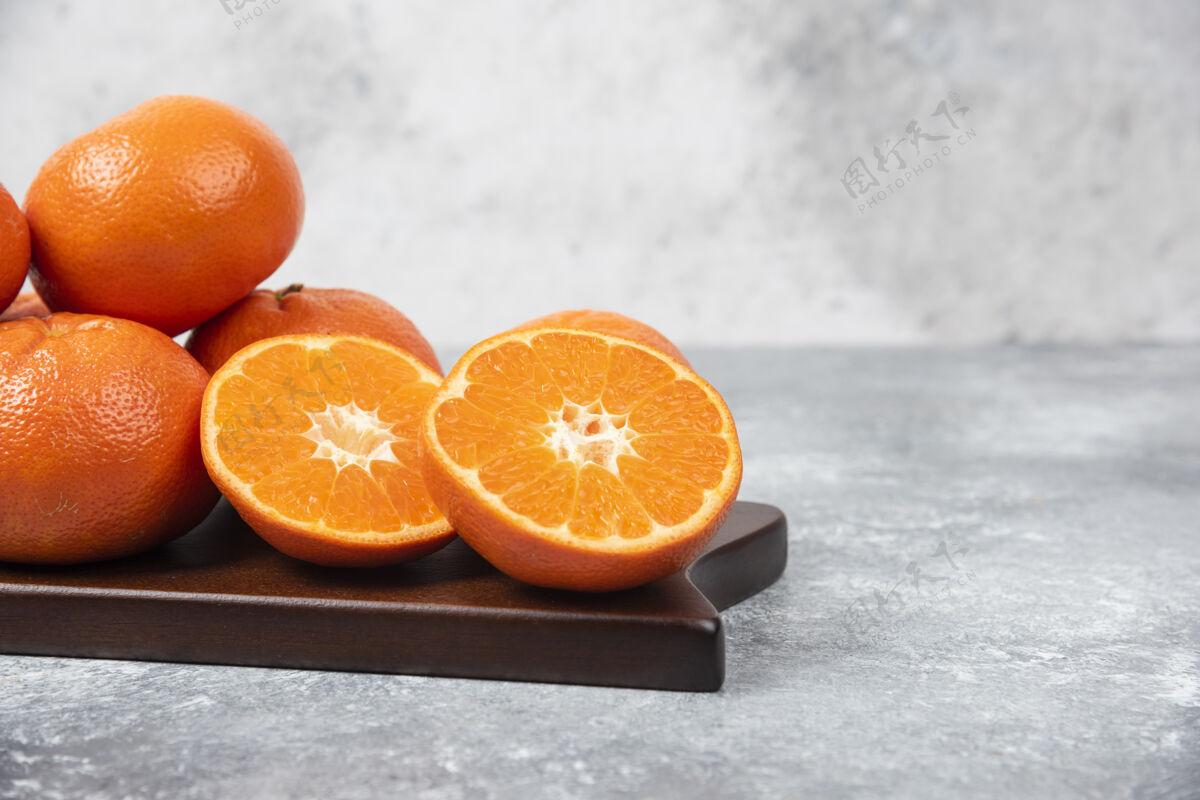 多汁石桌上摆满了橙汁水果的木板圆形美味水果