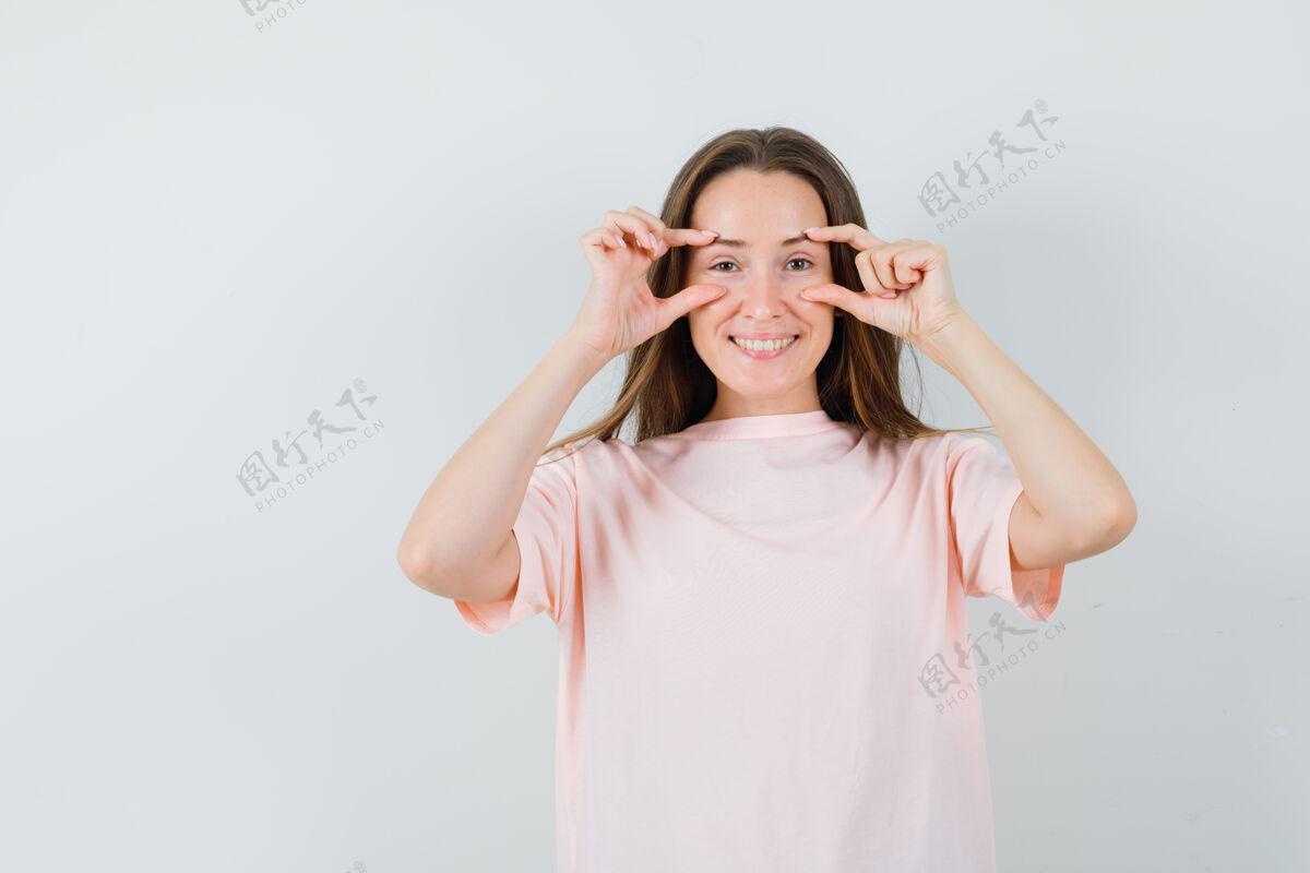 休闲穿着粉色t恤的年轻女士睁开眼睛 看起来很乐观T恤手指女士