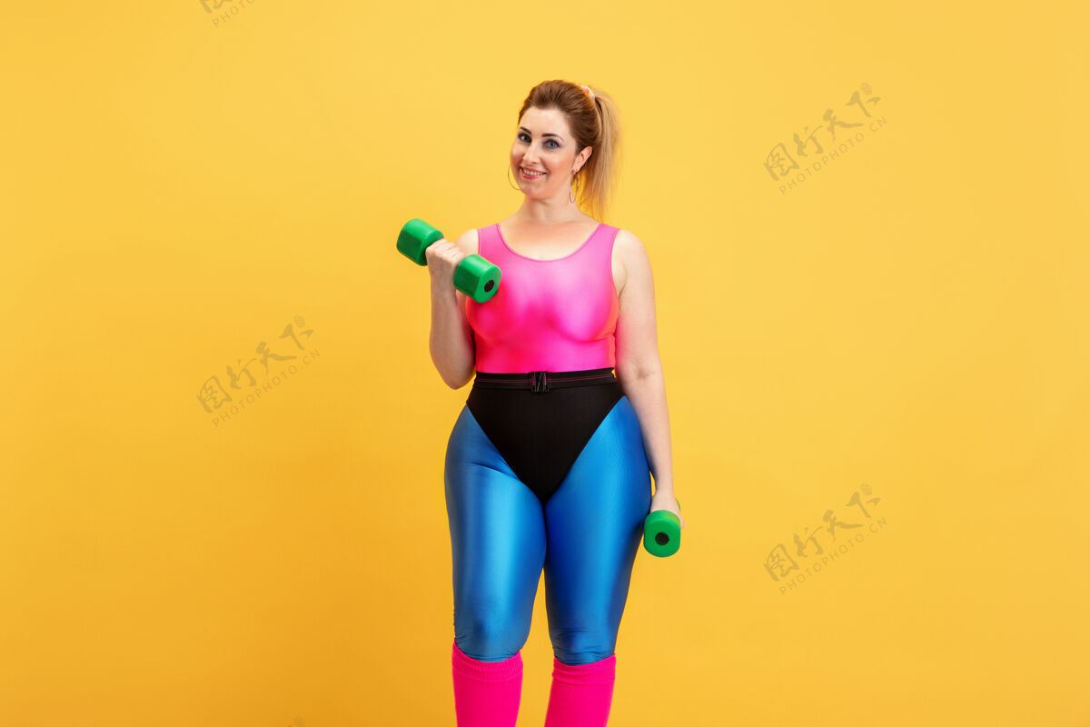 活力年轻的白种人大码女模特的黄色训练身体运动体重