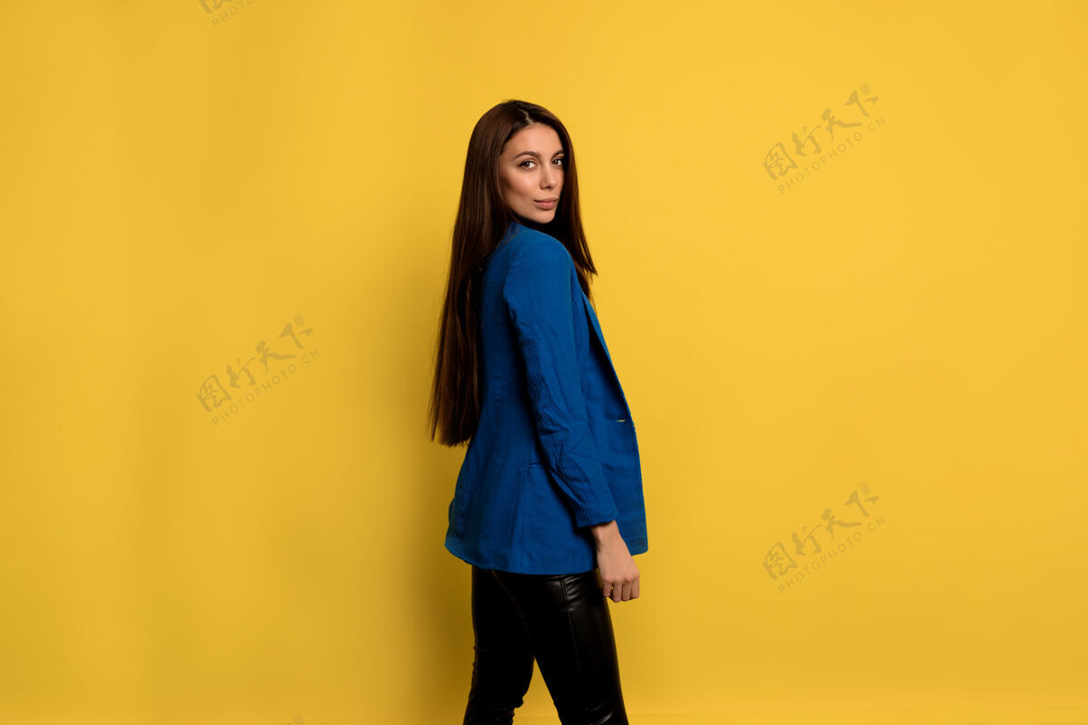 聪明迷人的时尚女性 深色长发 穿着蓝色夹克 微笑着在隔离的墙上摆姿势微笑快乐专业