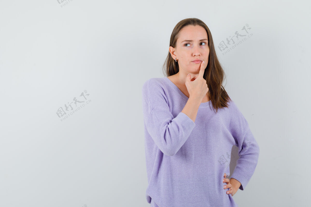 持有穿着休闲衬衫的年轻女士把手指放在下巴上 神情沉思前视图头发护理完美
